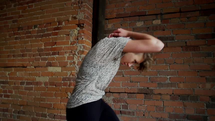 A woman dancing in front of a window