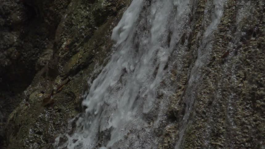Water cascades down a boulder