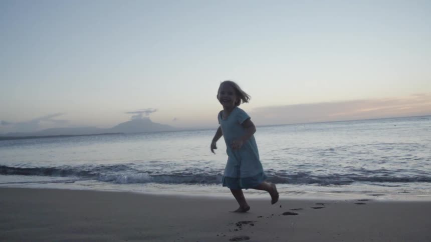 Child running from the water onto a beach