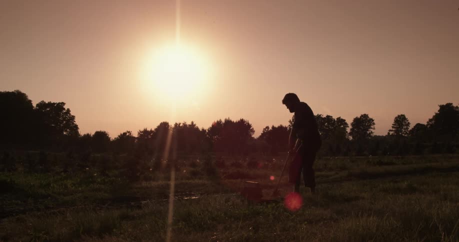 A man chopping wood at sunset