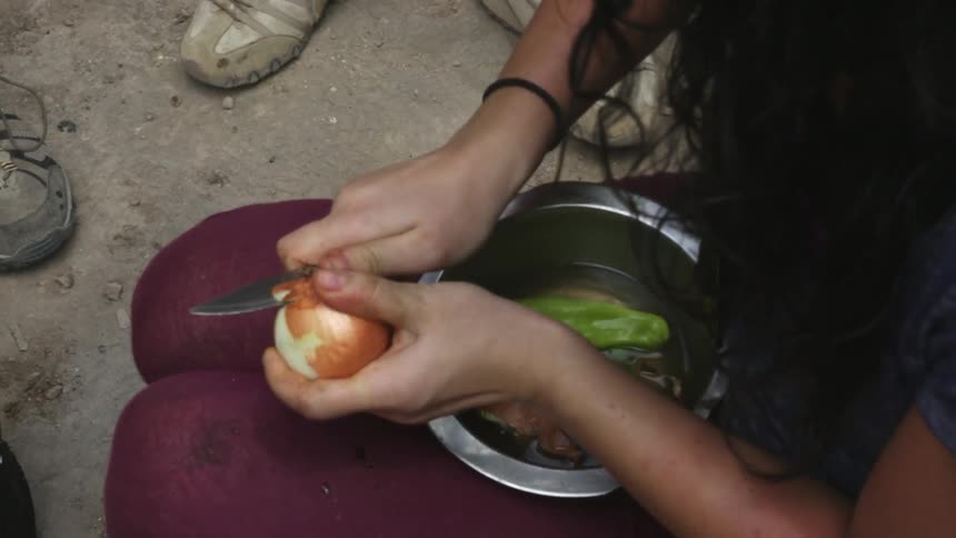 A woman is peeling potatoes