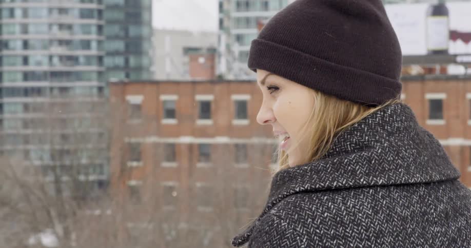 Woman standing on a balcony overlooking a city