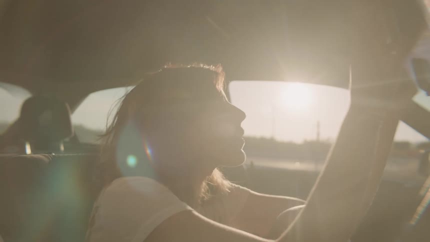 Woman sits in passenger seat and fixes her hair