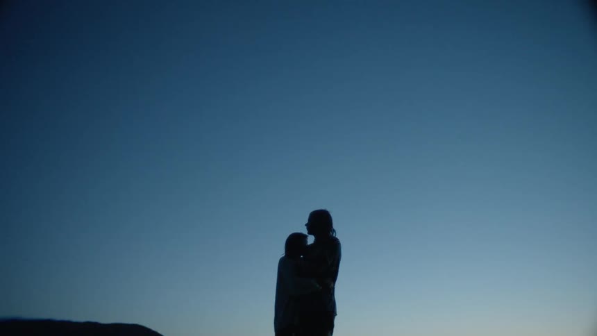 Two people hug at sunset