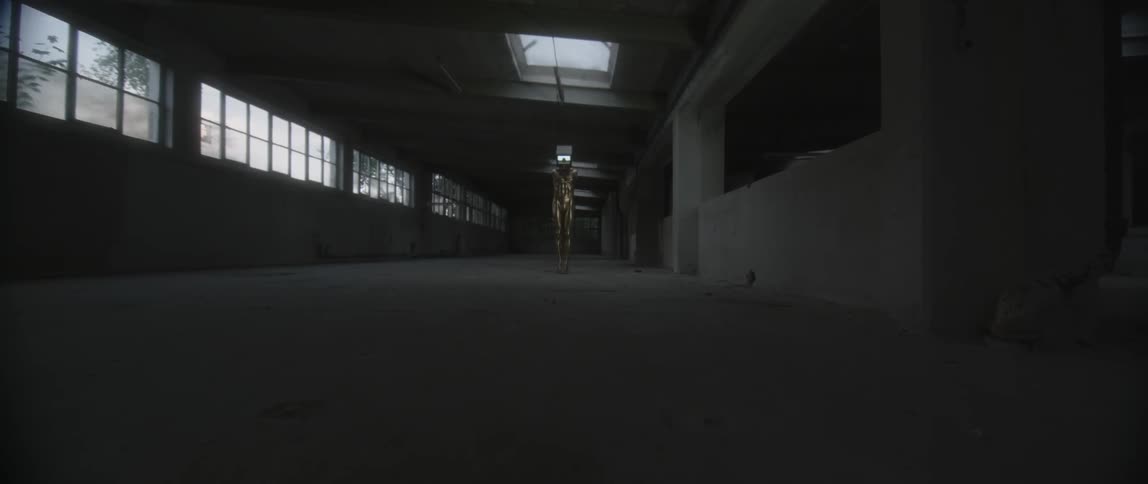 A television flashes in a dark warehouse