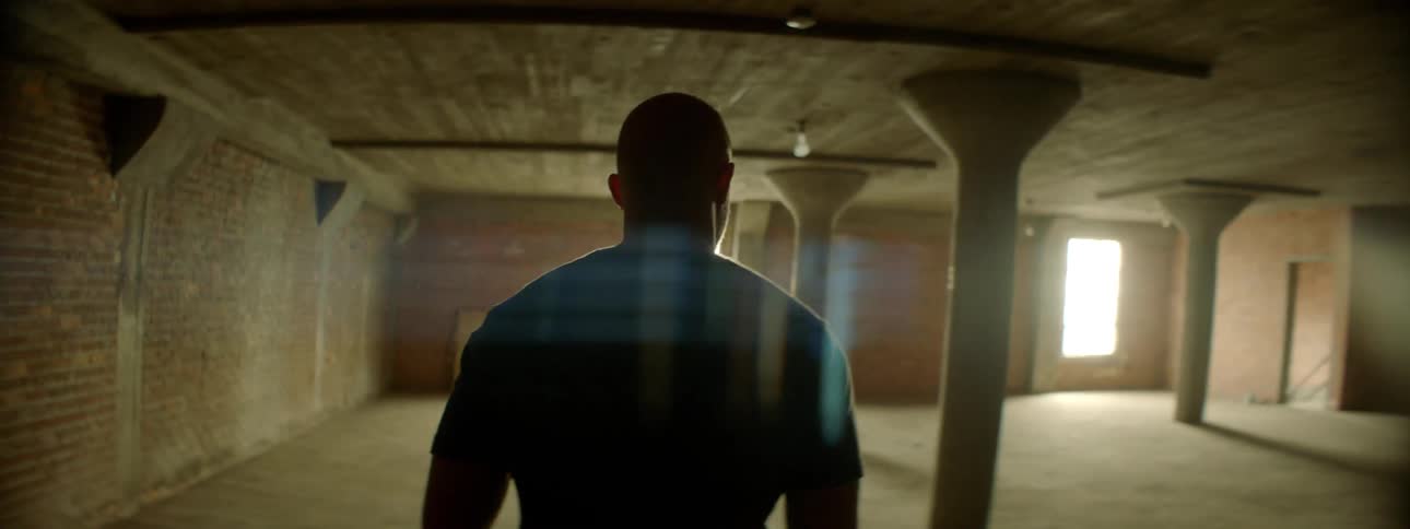 Man walks through a large room as the sun streams through the windows