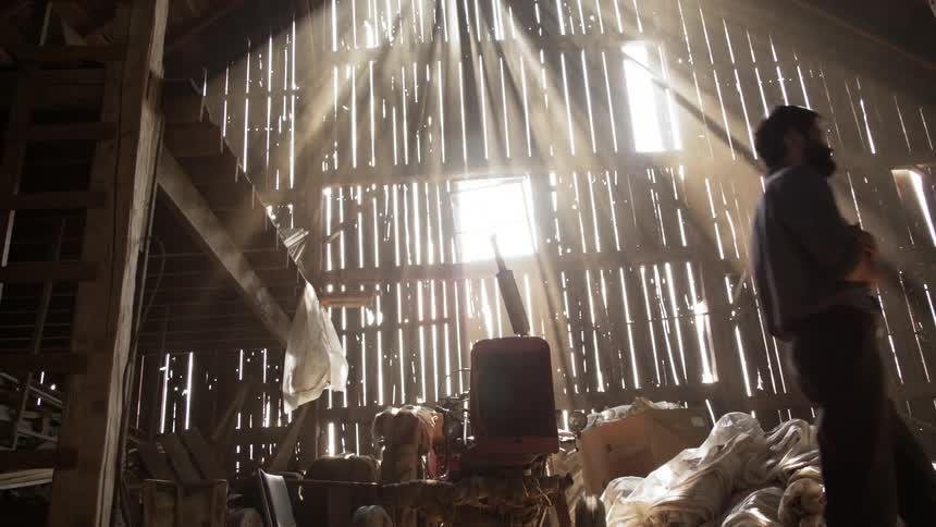 A man walking through a barn