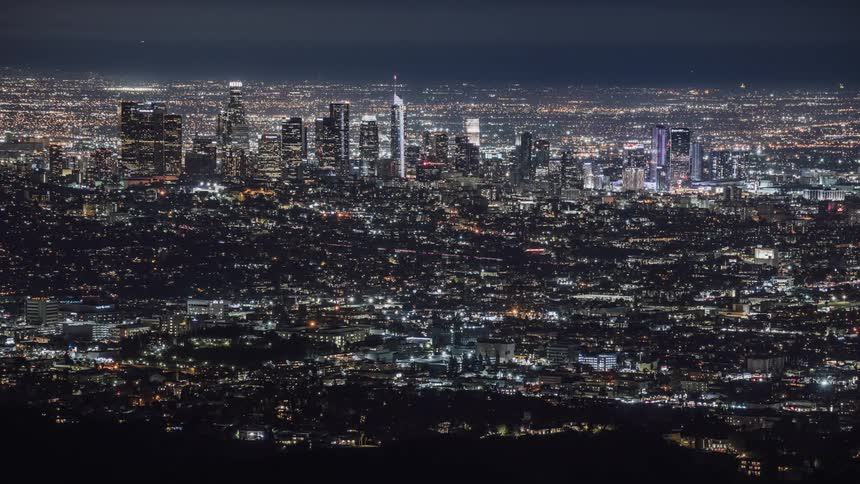 Lights from traffic and buildings glow in the city skyline at night