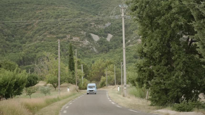 A vehicle drives on a rural road