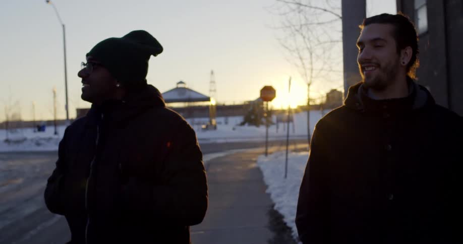 Two men walking on a sidewalk on a cold winter morning