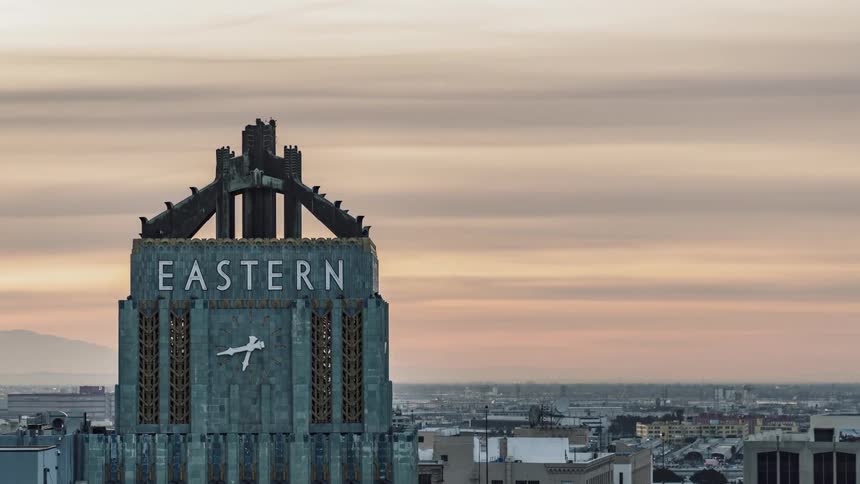 A clock on the outside of a high rise is ticking away the hours throughout the day