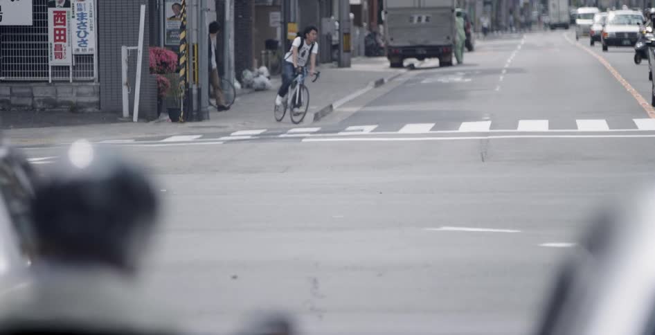 Cars and bicyclists travel on a city street
