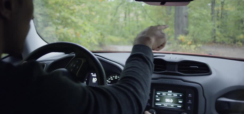 A man drives a car in a forest