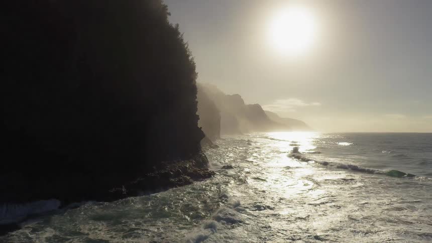 The rough waves crash against the cliffs