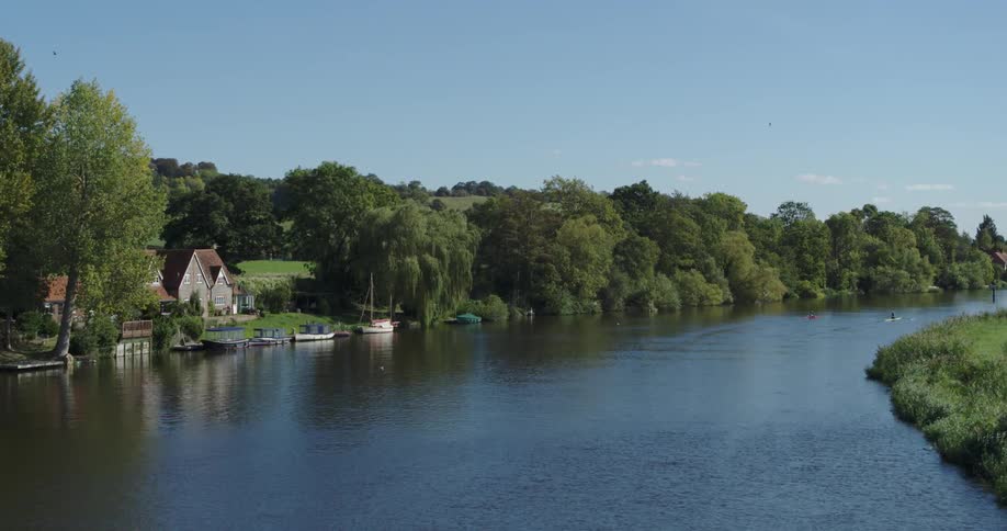 People rowing boats together down a river on a clear day