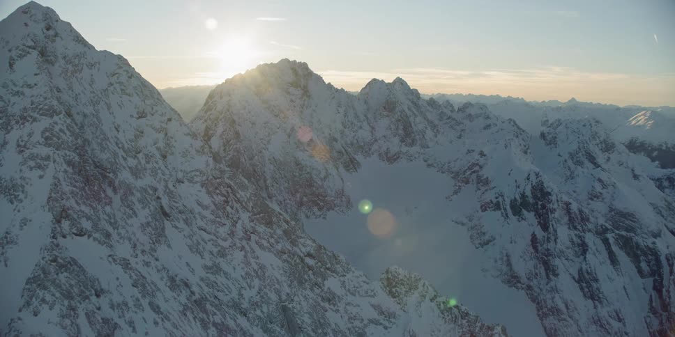 The mountains ahead have a sun setting behind