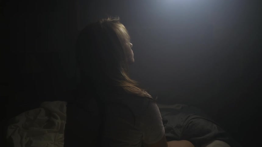 A woman looks up towards light
