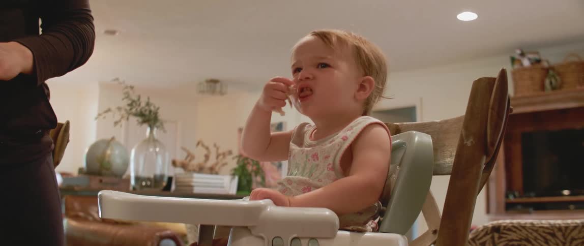 A baby eats in a highchair