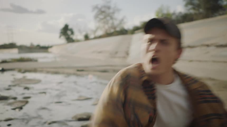 Two men fighting outside in a stream