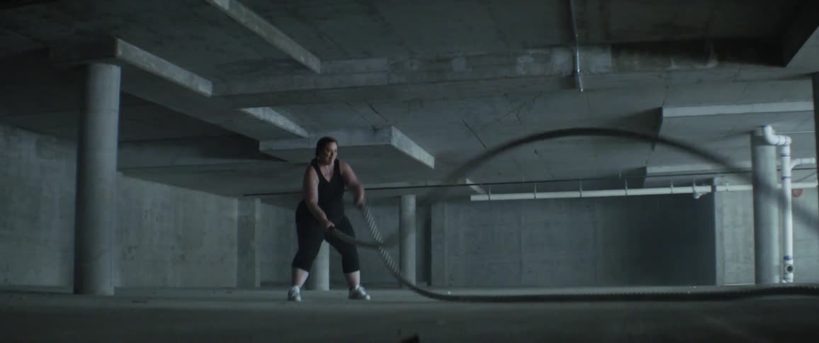 Woman slamming two ropes on a warehouse floor
