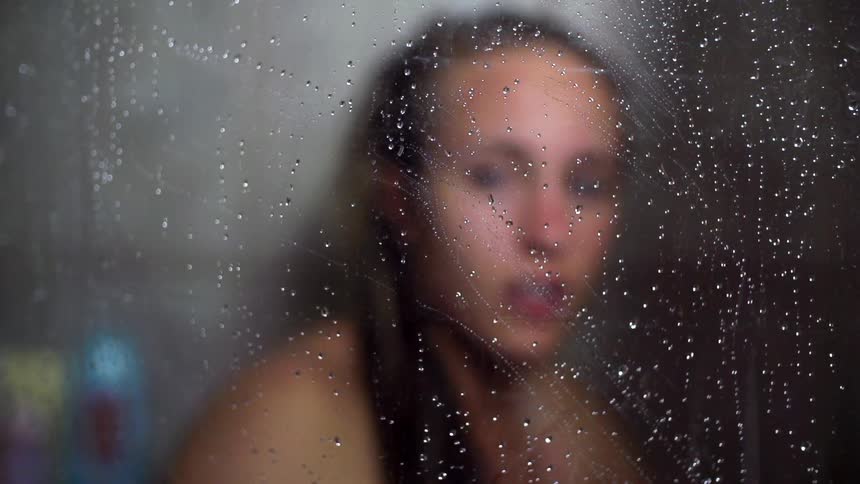 Portrait of a female under rainy glass