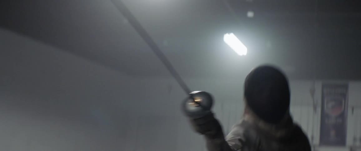 Person practices fencing while wearing a protective mask