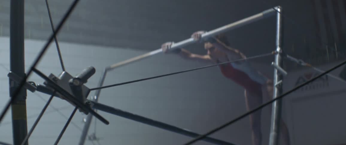A woman is doing gymnastics on a bar