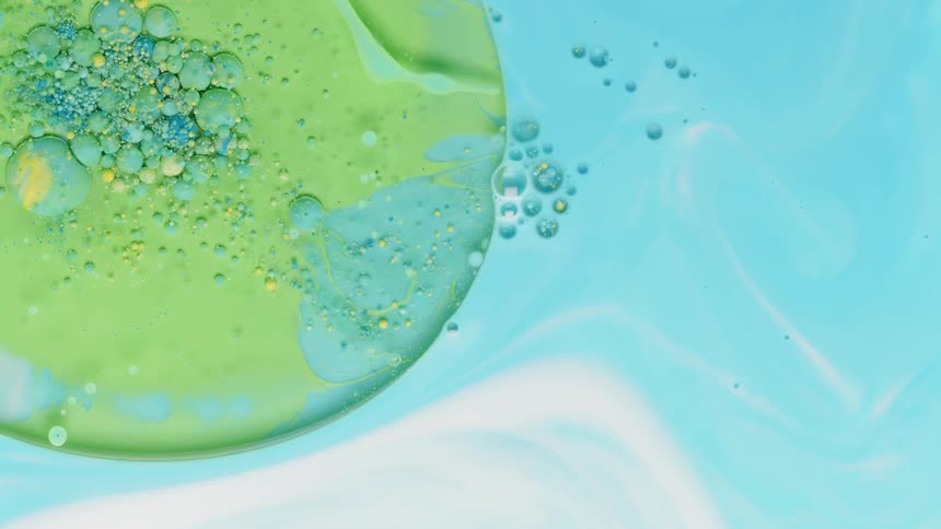 Blue and green colored liquid with bubbles forming on top
