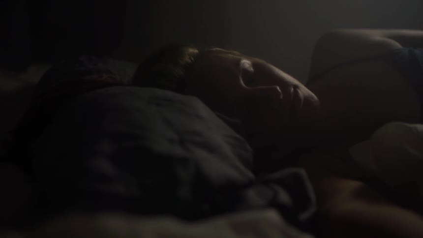 A woman is laying in bed sleeping,