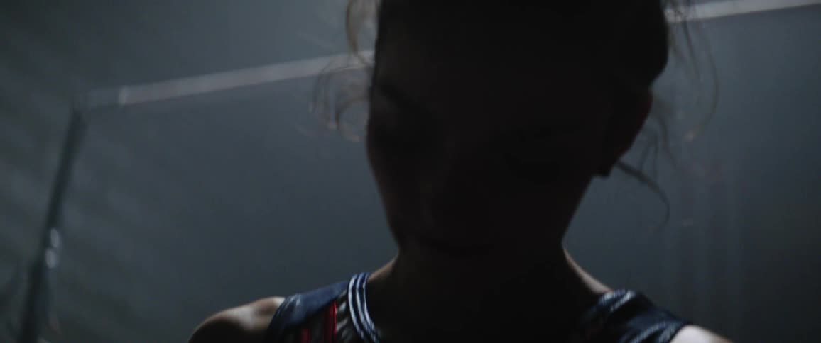 A gymnast looks down at her hands