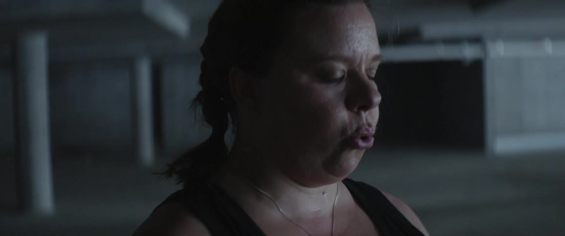 A woman breathes heavily during a workout
