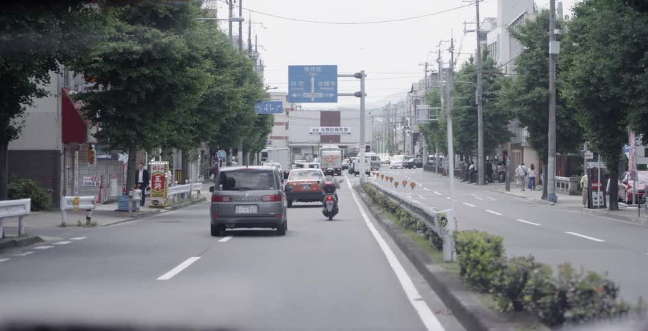 Many vehicles drive down a busy city street