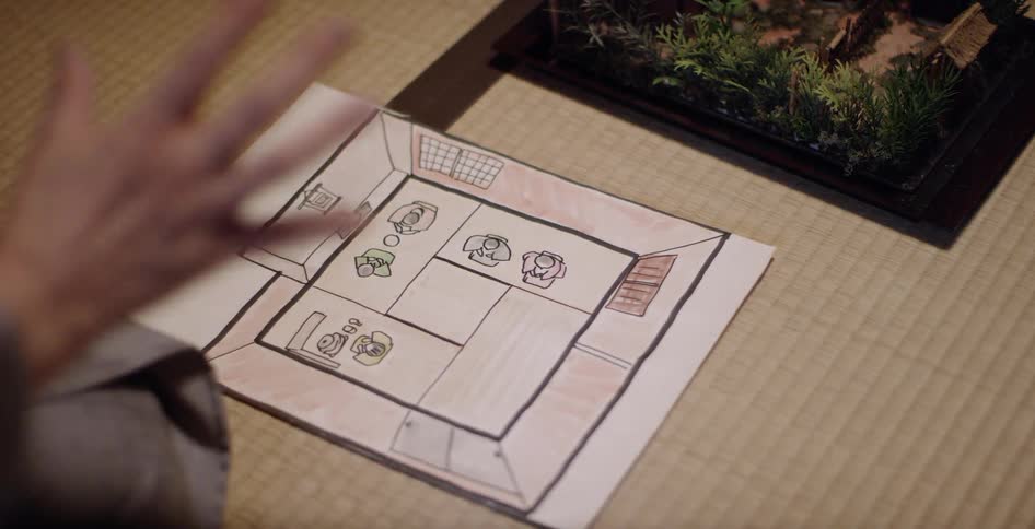 A hand points at a floor plan