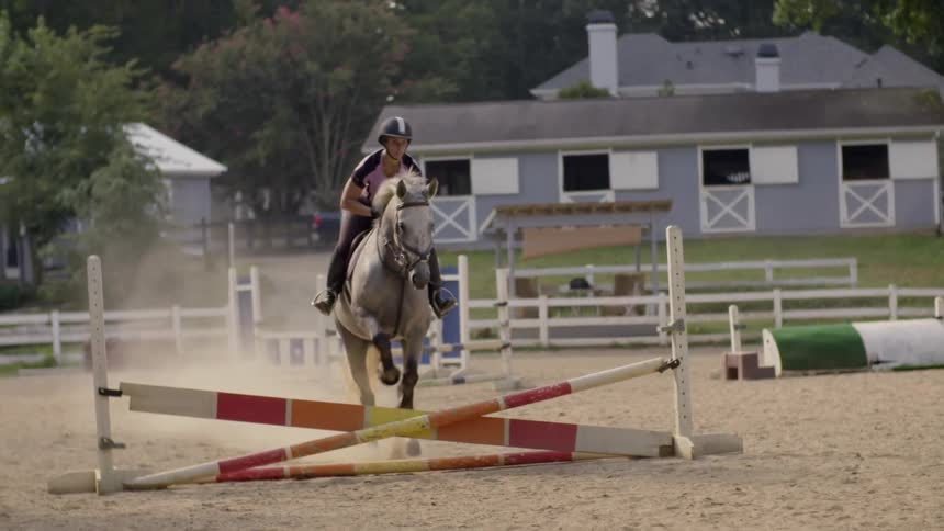 Man riding a horse over a jump