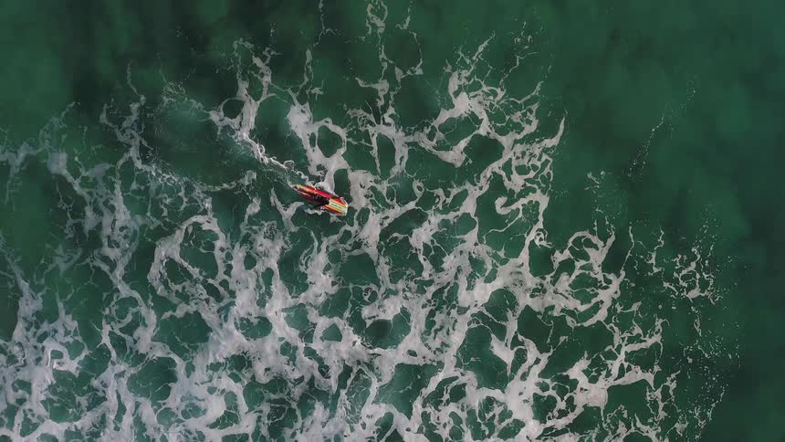 A person paddles in the water inside a kayak