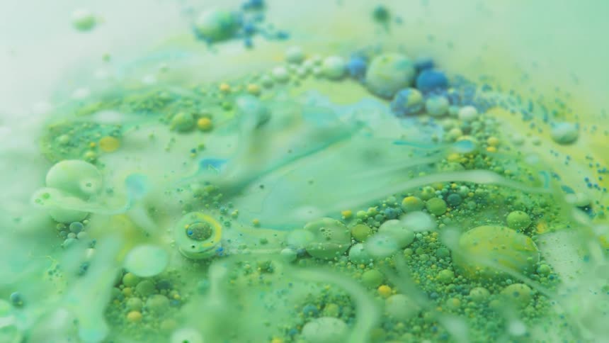 The liquid is green with blue and has many bubbles