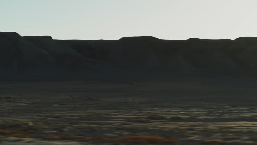 People stand near unloaded suv's on a barren landscape