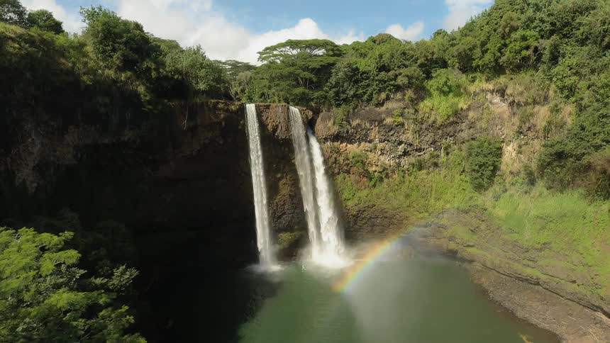 The waterfall creates a small rainbow