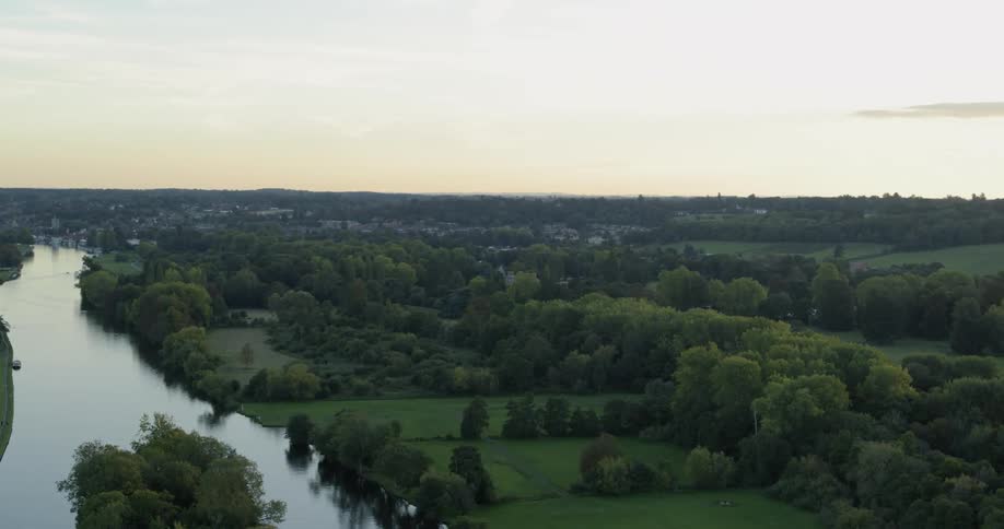 A river flows through a rural landscape at sunset