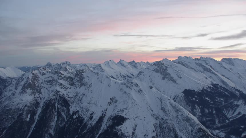 Snow covered mountains under a cloudy blue sky