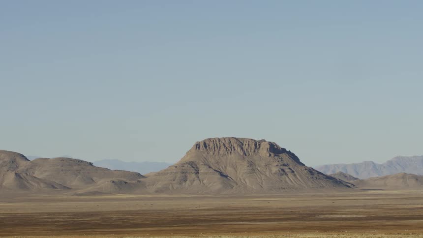 The mountain range is in the distance under the clear sky