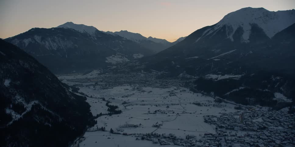 The sun sets over snowy mountains