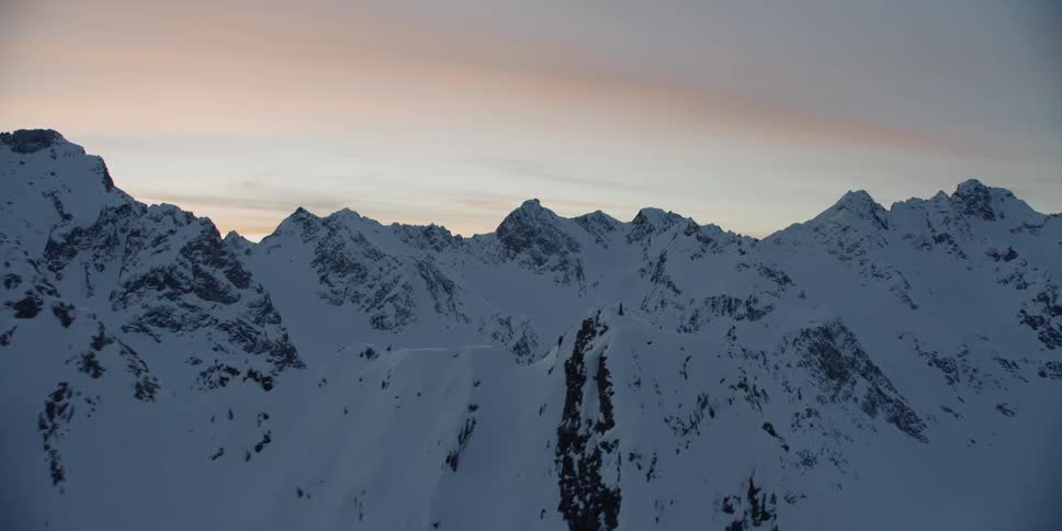 Snow covers mountains at sunset