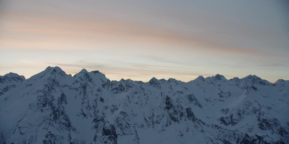 Snow-covered mountains at a somewhat cloudy sunset