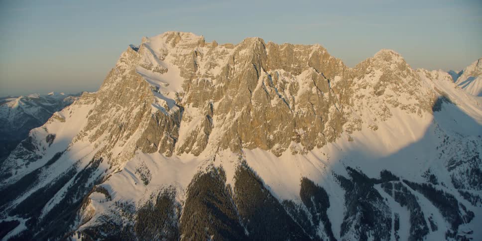 The sun sets over snowy mountains