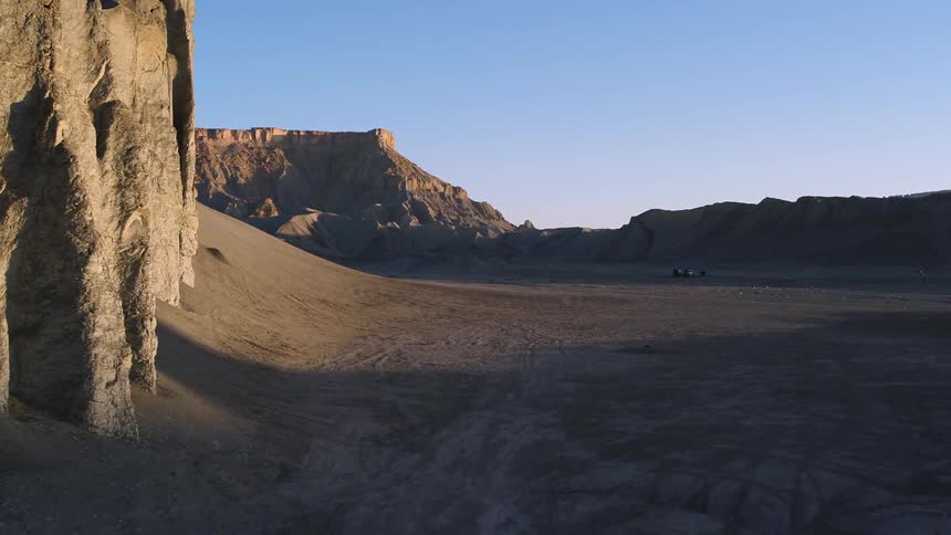 Sun shines down over a desert with tall plateaus