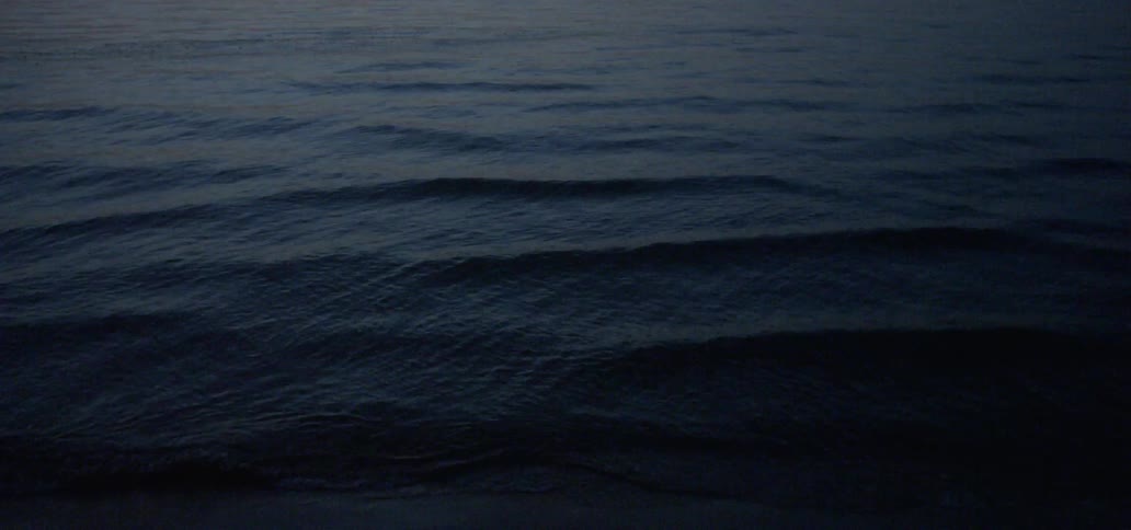 Water flows on an ocean at sunset