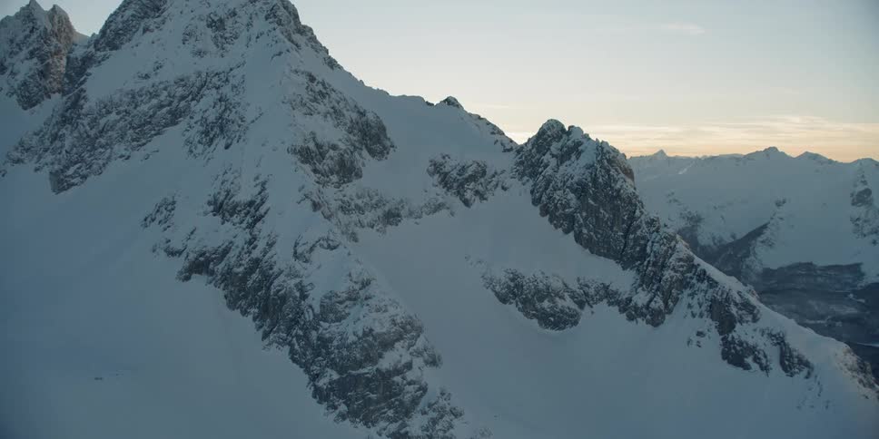 The sun sets over snowy mountains