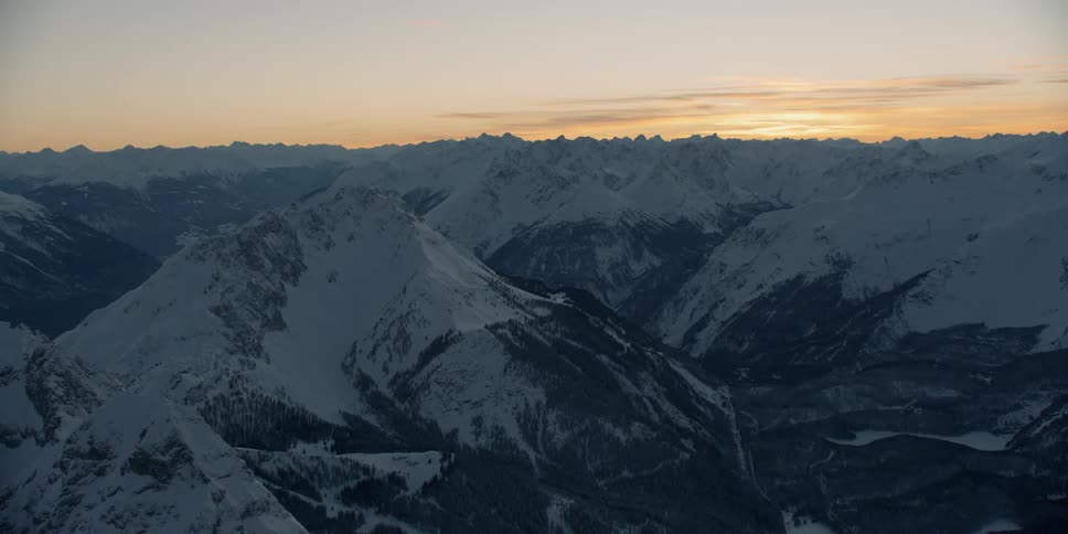 The sun is setting behind the large mountain range