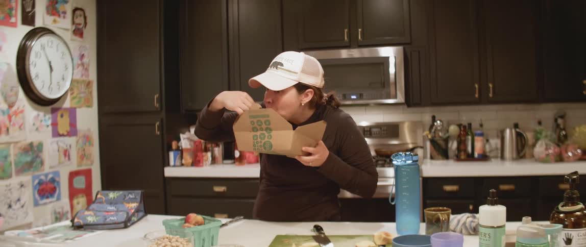 A woman is eating food at the kitchen counter